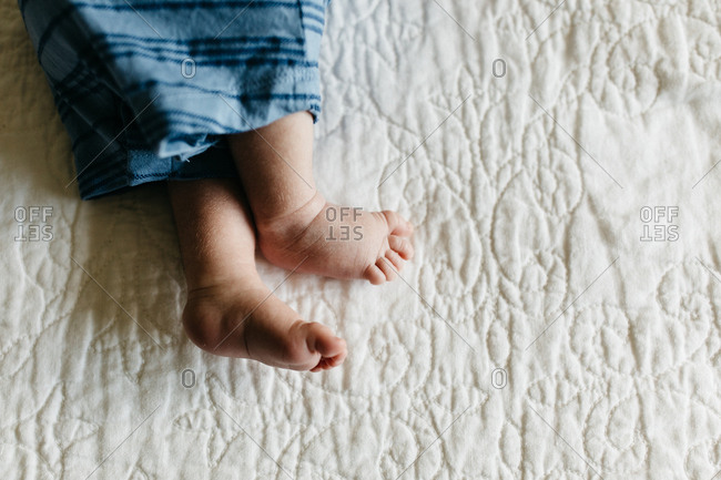 Tiny newborn baby feet on white blanket