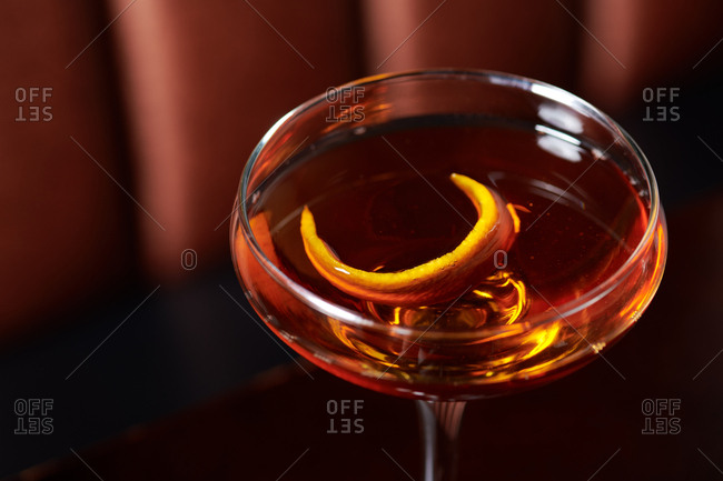 Old Fashioned cocktail of whiskey with a orange twist served in a stemmed glass