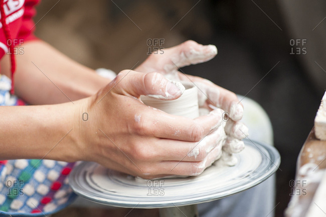 Junge tpfert eine Vase aus Ton