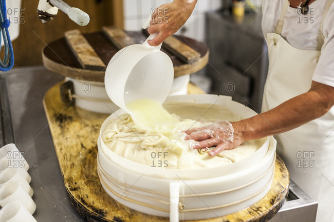 Die Sennerin verarbeitet frische Milch zu wrzigem Alm-Kse, der Ksebruch wird aus dem Kessel gehoben und zu einem Laib weiterverarbeitet,