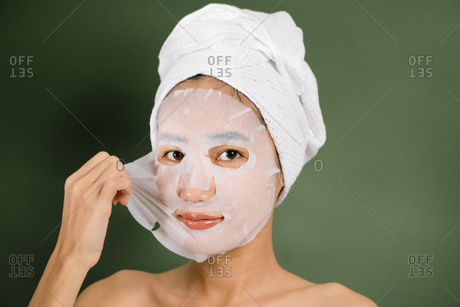 Woman peels off her face mask