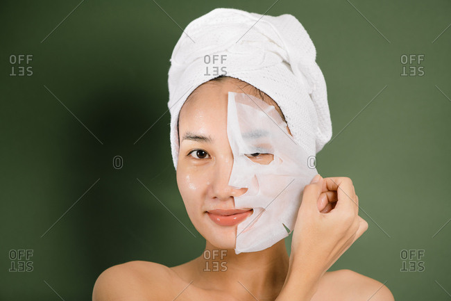 Young beautiful woman removes her face mask