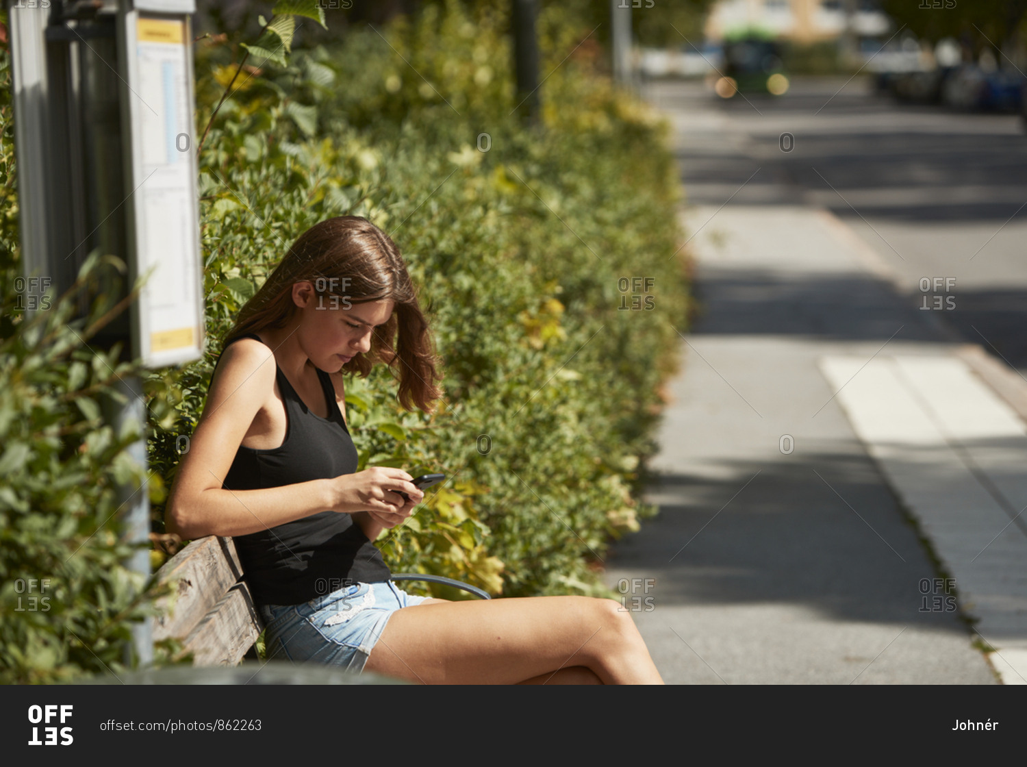 Woman sitting on bus stop