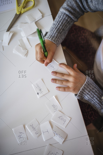 Girl writing on pieces of paper