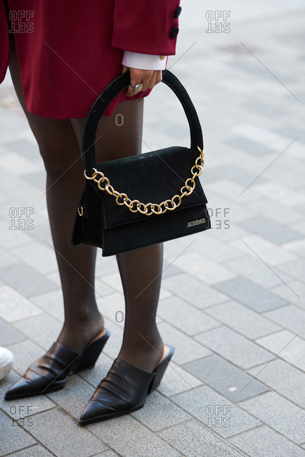September 14, 2019 - London: Chic Parisian woman holding black Jacquemus handbag