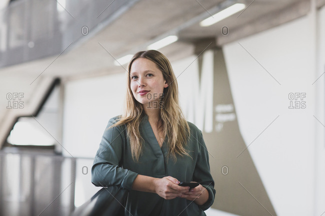Portrait of female executive holding a smartphone