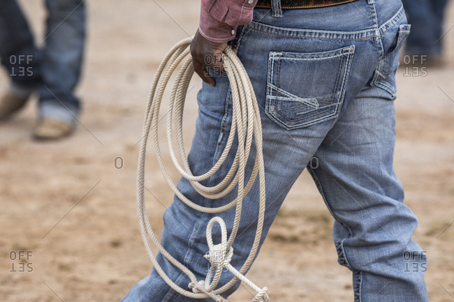 A cowboy carries his rope backstage at the Arizona black rodeo