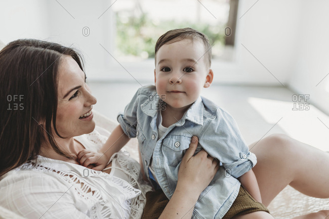 Mother and young son swinging in hammock in natural light studio