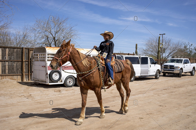 United States, Arizona, Chandler - March 9, 2019: A young rider warms up her horse backstage at the Arizona Black Rodeo