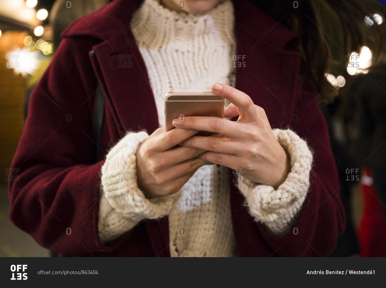 Hands of young woman holding smartphone- close-up