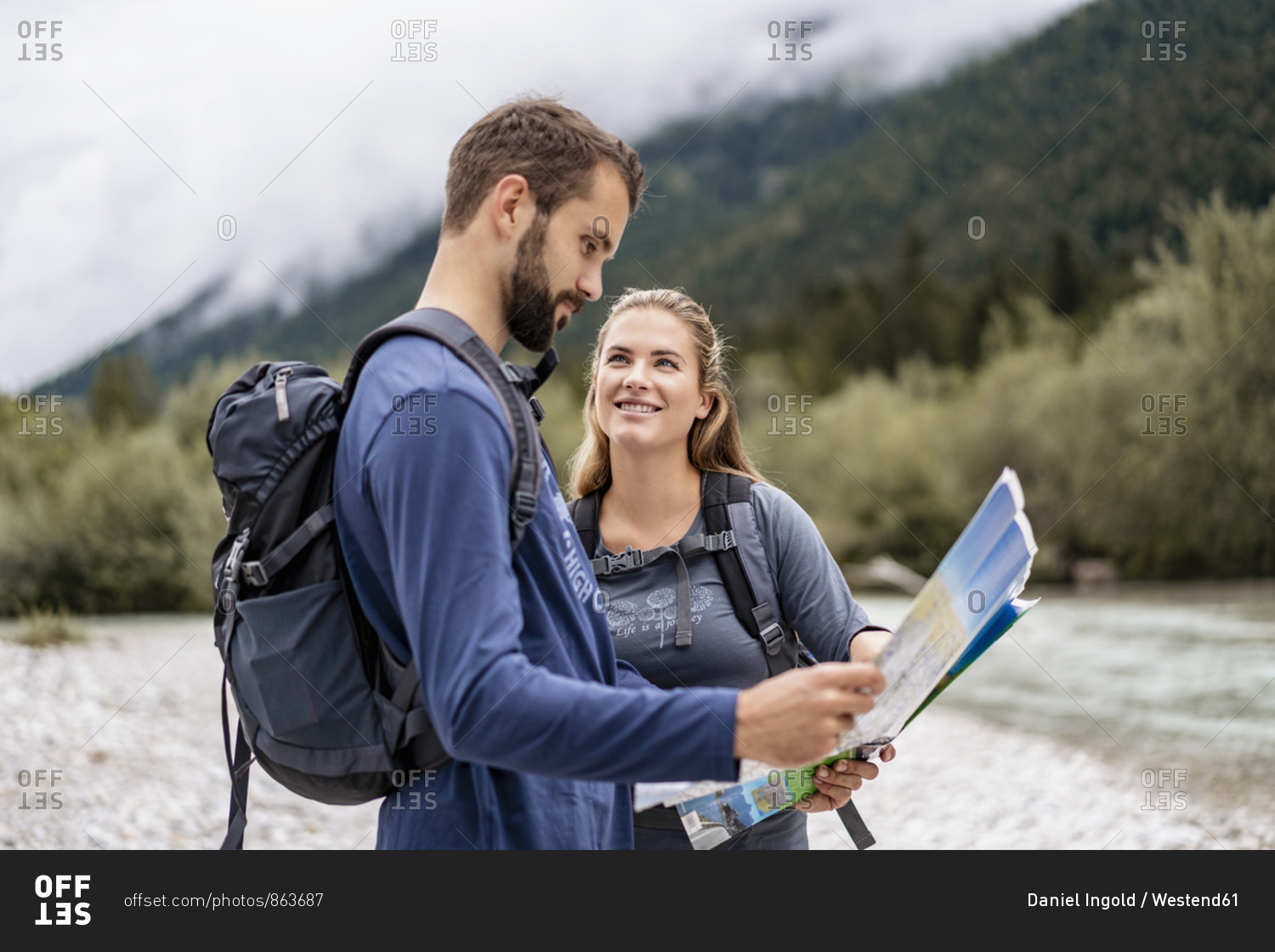 Young couple on a hiking trip reading map- Vorderriss- Bavaria- Germany