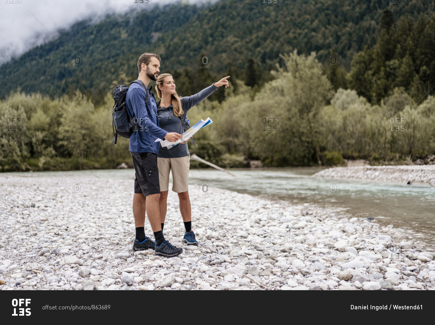 Young couple on a hiking trip with map looking around- Vorderriss- Bavaria- Germany