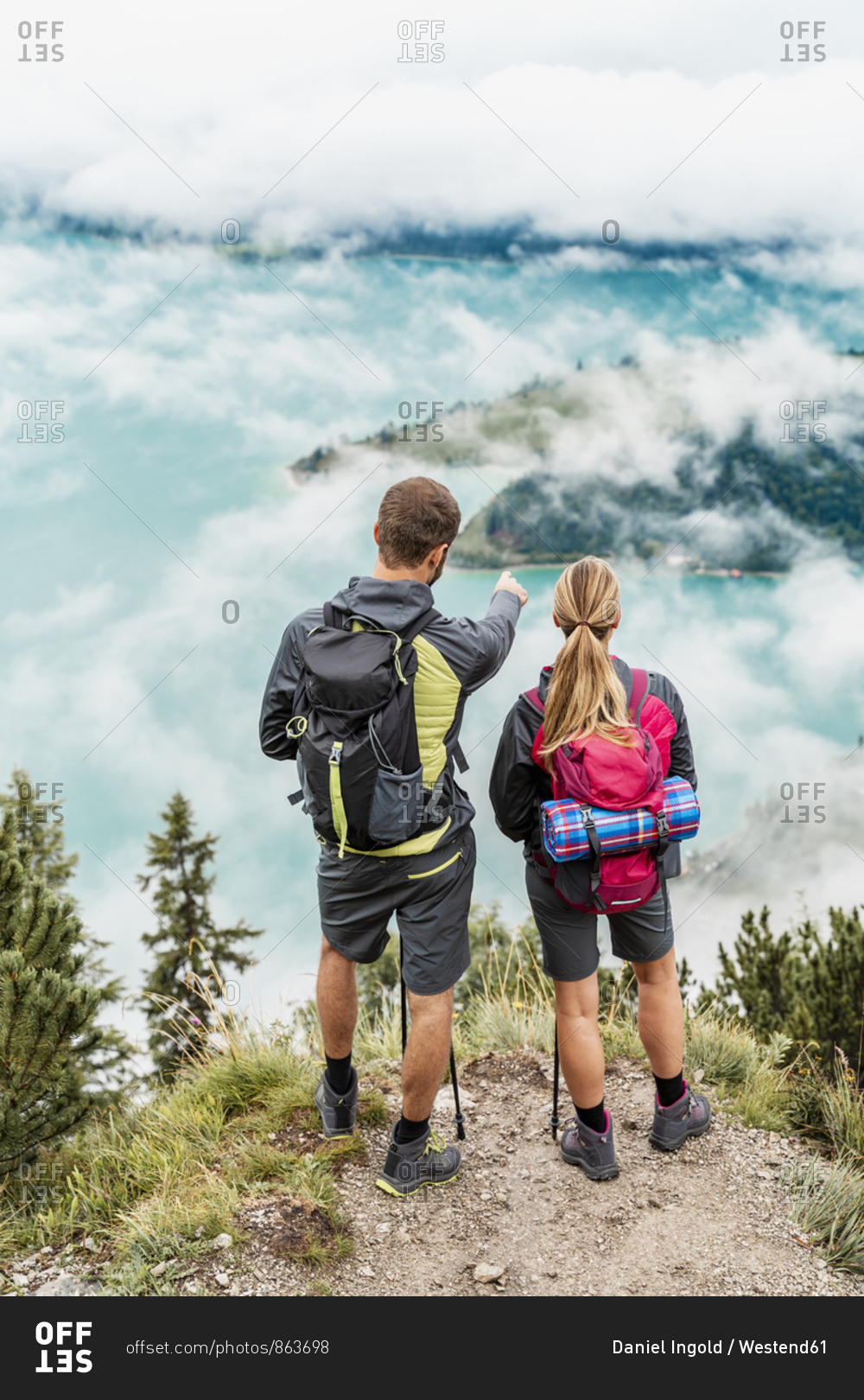 Young couple on a hiking trip in the mountains looking at view- Herzogstand- Bavaria- Germany
