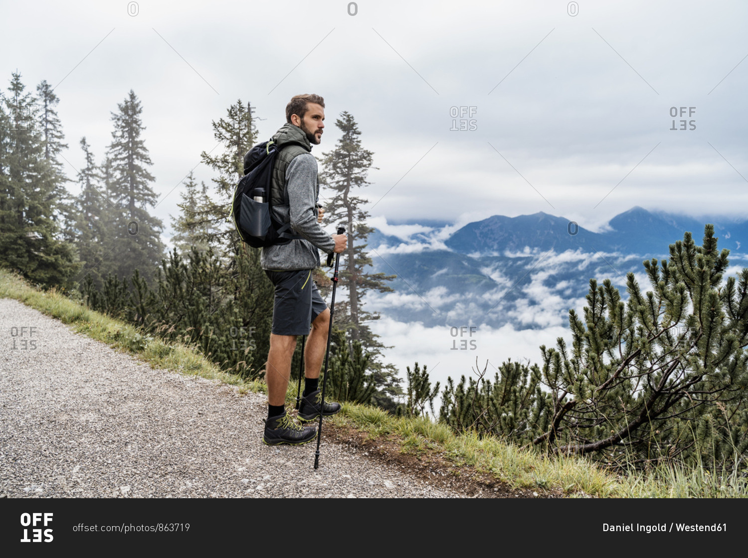Young man on a hiking trip in the mountains looking at view- Herzogstand- Bavaria- Germany