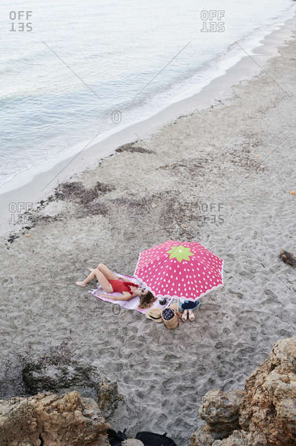 Young woman lying on towel at the beach sunbathing