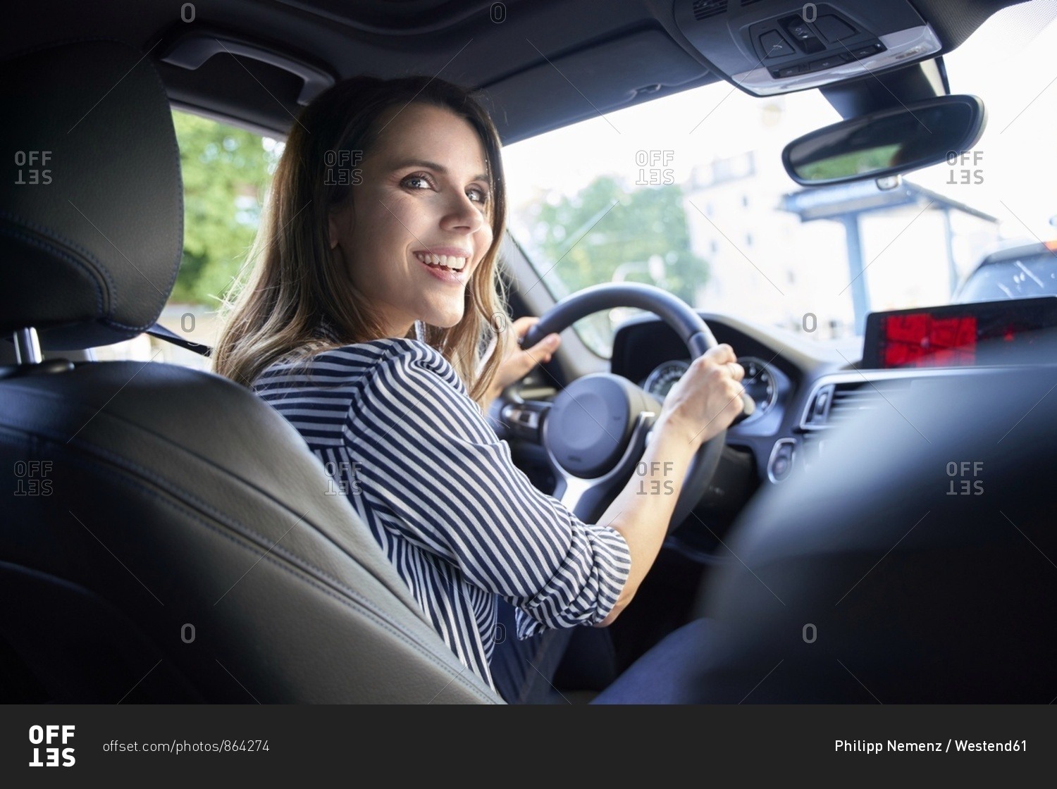 Happy woman driving car - Offset stock photo - OFFSET