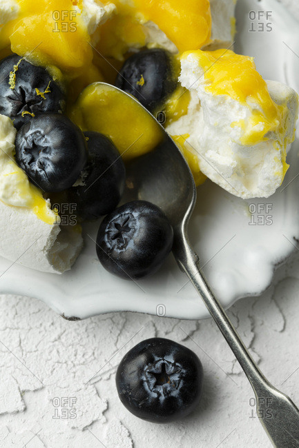 Mini lemon curd pavlovas on a white background