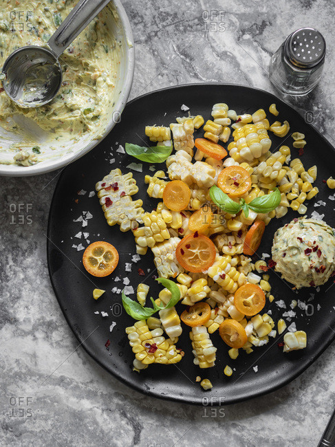 Shaved mexican street corn with herbed butter scoop on the plate.