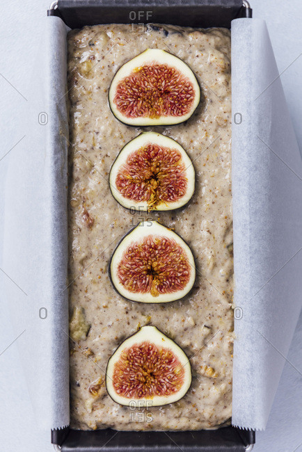 Vegan fig bread batter in a loaf pan topped with fresh figs