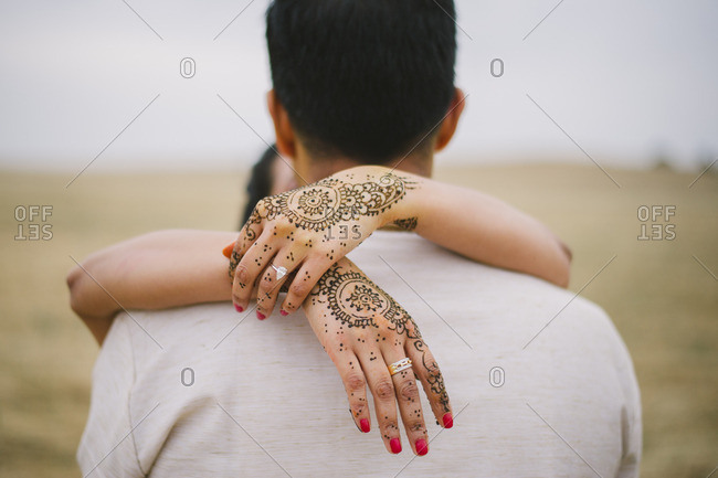 Portrait Of A Newly Married Couple Wearing Traditional Indian Clothes And  Woman's Hands Painted With Henna