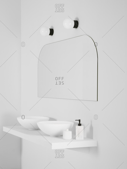 Ceramic bowl placed on simple shelf against white wall in bathroom with mirror