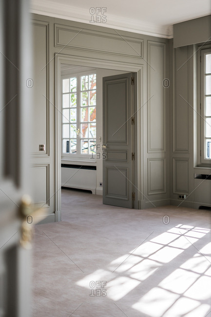 Open white door with golden handle in light minimalist interior