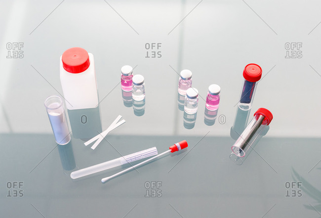 From above arrangement of test tubes strips bottles and vials with fluid for conducting scientific research in laboratory