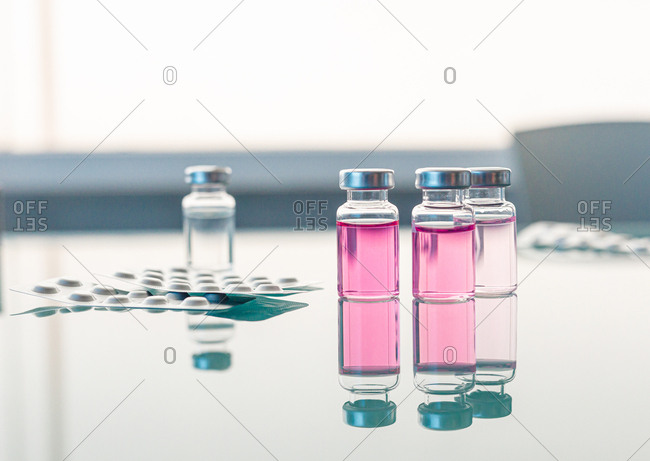 Vials with scientific samples arranged on glass table