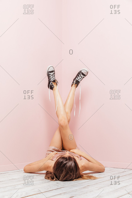 woman's aesthetic legs looking up on pink background