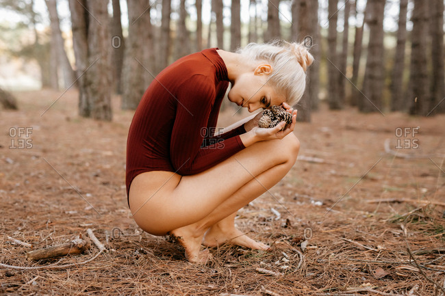 Beautiful modern woman resting barefoot in evergreen forest