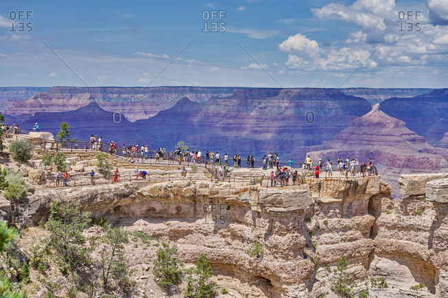 Grand Canyon National Park, Arizona - August 4, 2019: Tourists on lookout cliff overlooking canyons
