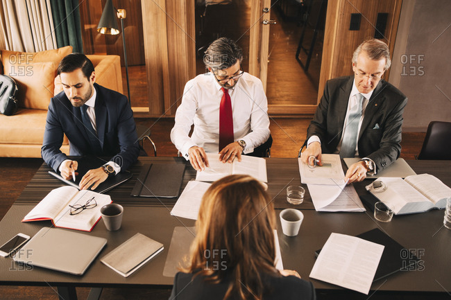 High angle view of female financial advisor planning with male lawyers in meeting at board room