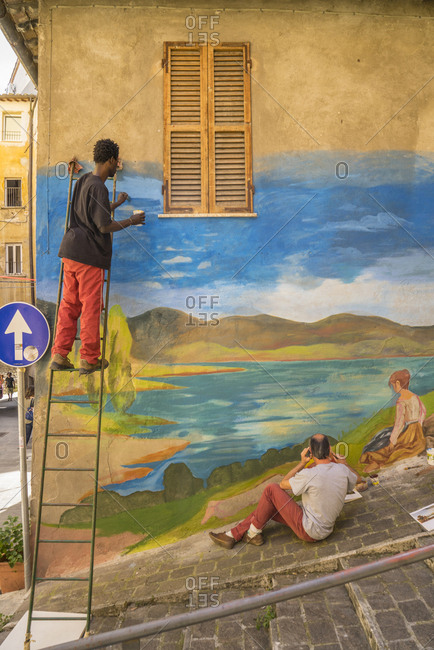 June 18, 2016: Italy, Umbria, Perugia . Via della Viola during "Alkemika" street art festival. Artist painting a wall murales inspired by peace and harmony