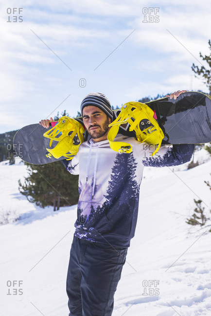 Portrait of man in winter wilderness with snowboard