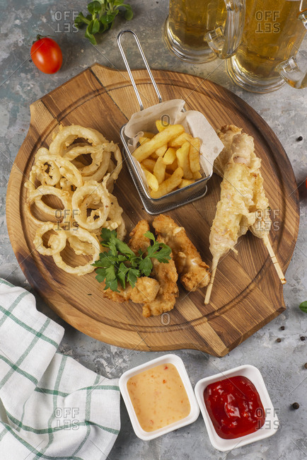 Deep fried snacks on cutting board with sauce