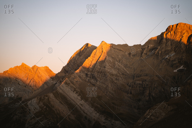Sunset golden light hitting the hills of a big mountain in Pyrenees