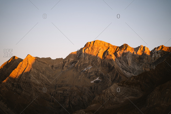 Sunset golden light hitting the hills of a big mountain in Pyrenees