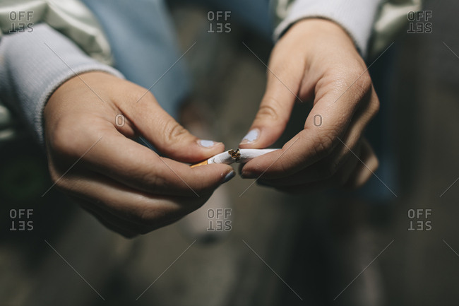 Close up of young hands preparing a weed cigarette in urban location