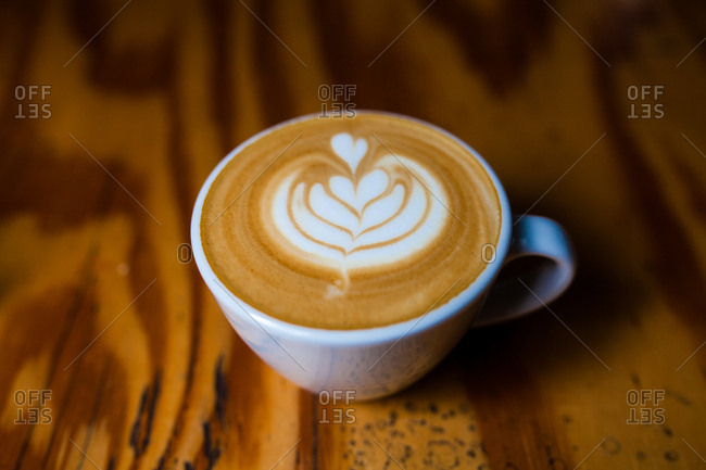 A freshly made cappuccino on a wooden table