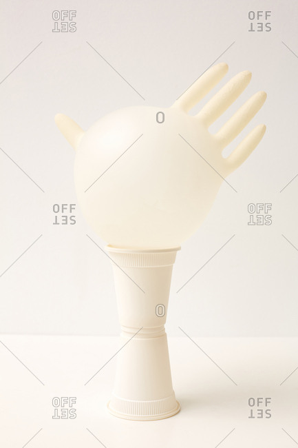 White inflated latex glove and two plastic cups installation