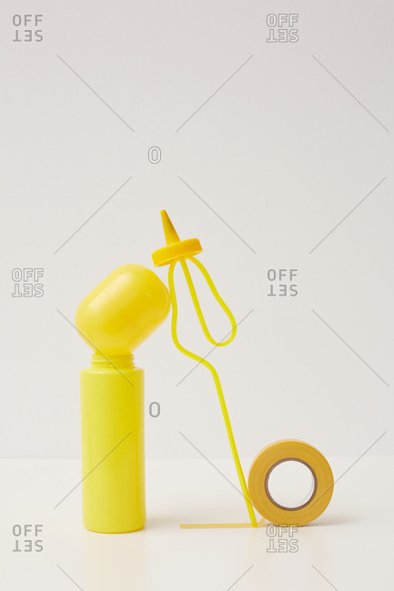 Yellow plastic bottle, container, straw and tape balance installation