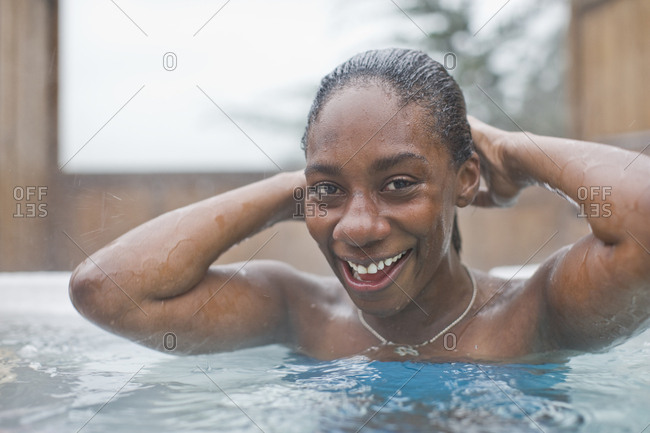 Woman smiling at the camera while relaxing in spa pool