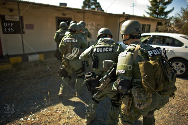 Group of police officers about to enter a building during an exercise at a training facility.