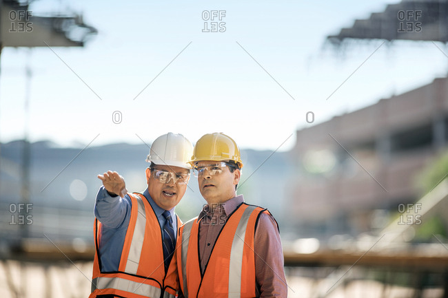 Workers at construction site discuss progress.
