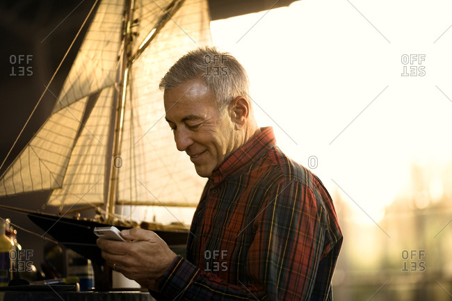 Smiling senior man sending a text message on a cell phone.
