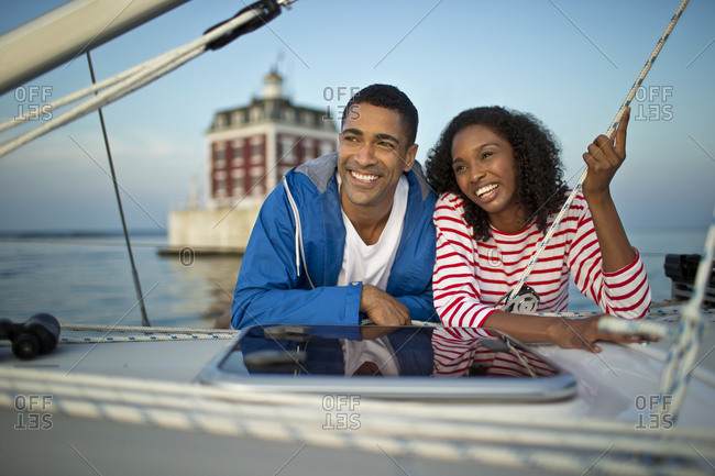 Smiling young couple hanging out on a boat.