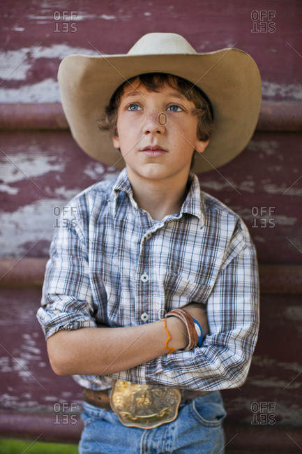 Portrait of a serious young boy dressed as a rancher.
