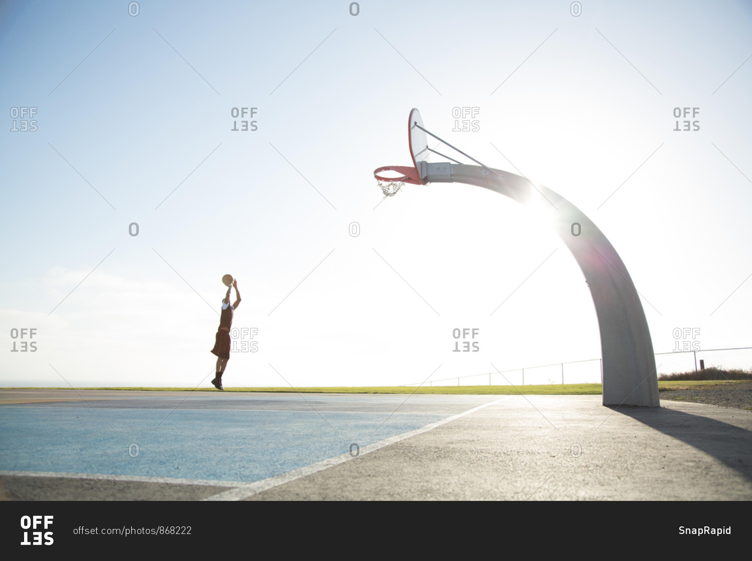 Young man playing basketball in a park, Los Angeles, California, United States