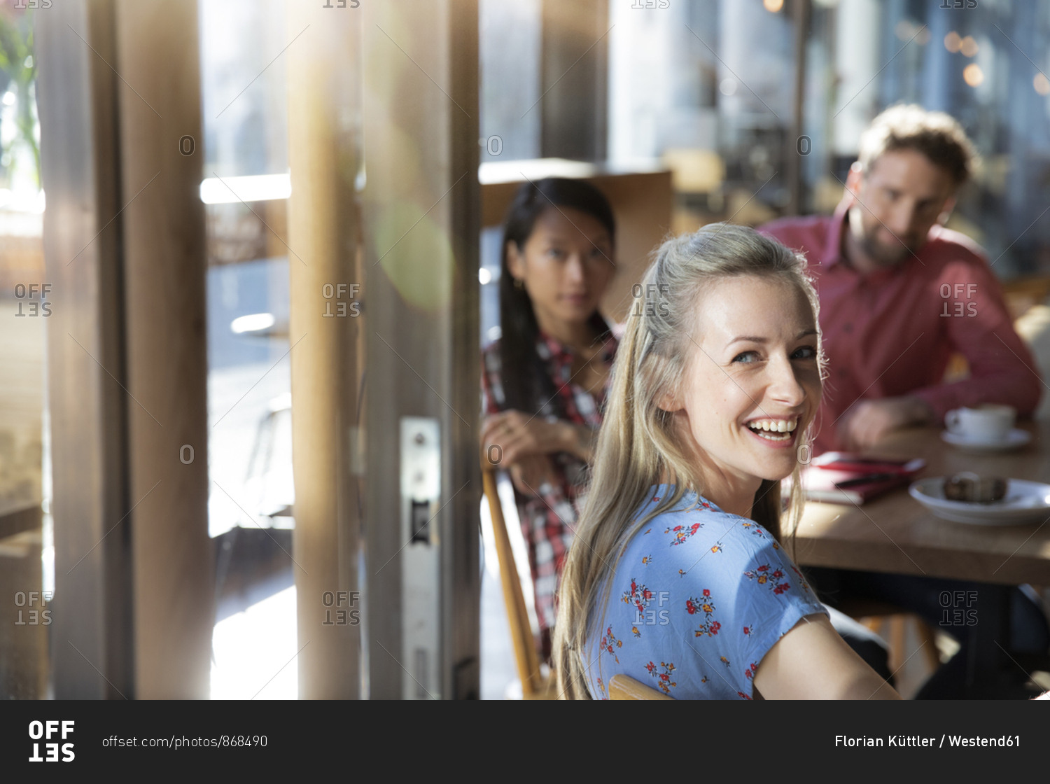 Portrait of happy woman with friends in a cafe