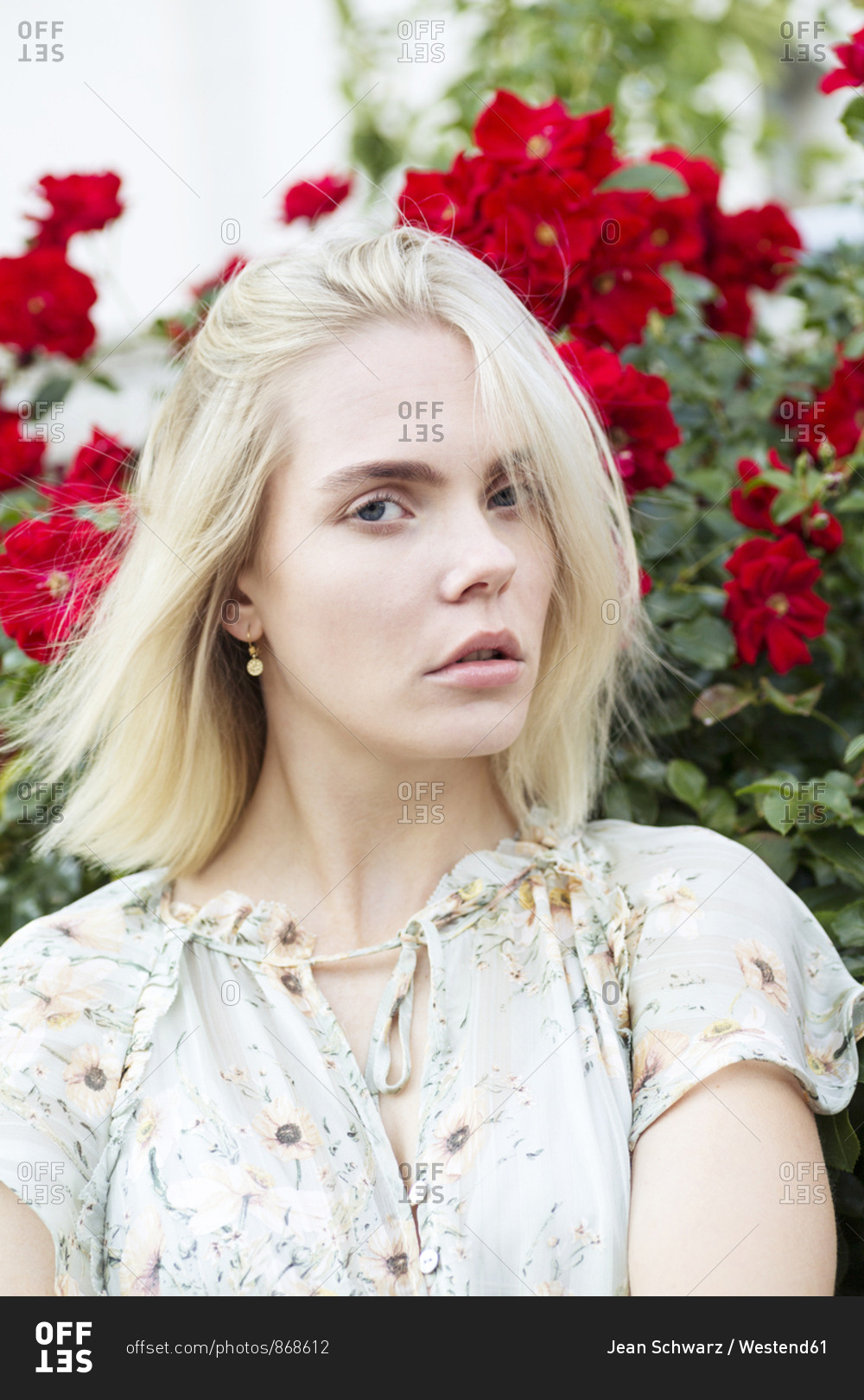 Portrait of blond young woman wearing summer blouse with floral design